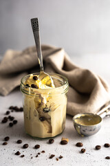 Vanilleeis in einem Trinkglas auf einem grauen Tisch. Stillleben.