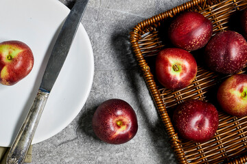 Fresh sweet ripe peaches in basket on gray grunge background