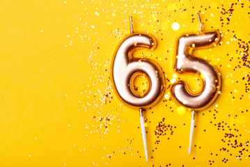 65 years celebration. Greeting banner. Gold candles in the form of number forty on yellow...