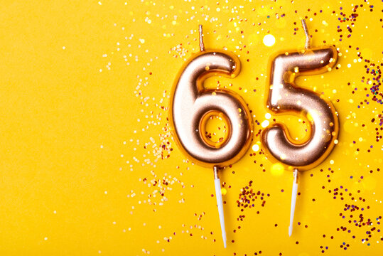 65 years celebration. Greeting banner. Gold candles in the form of number forty on yellow background with confetti.