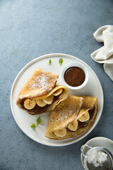 Homemade crepes with chocolate paste and banana