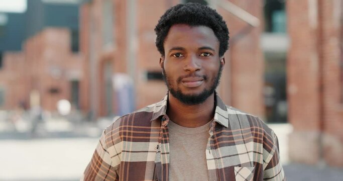 Portrait of a Black cheerful millennial pleasantly looking at camera.