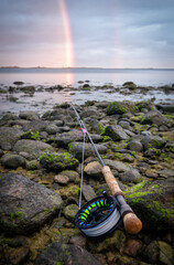 Fly rod on the sea coast with rainbow