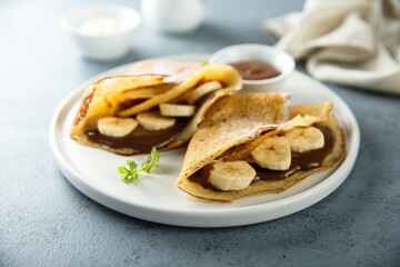 Homemade crepes with chocolate paste and banana
