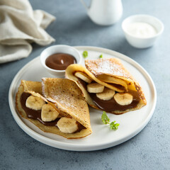 Homemade crepes with chocolate paste and banana