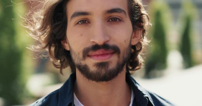 Portrait of a good-looking millennial guy pleasantly looking at camera. 
