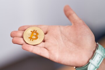 Young blonde woman holding bitcoin at office