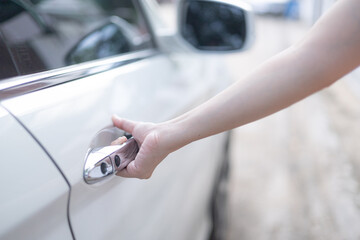 Close-up of a woman hand opening a white car door. Automotive concept. opening doors, concept cars, driving safely