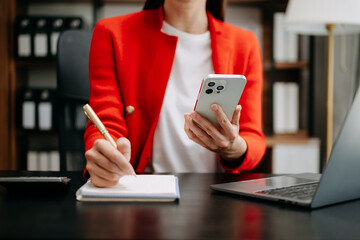 businesswoman hand working with new modern computer and writing on the notepad strategy diagram as concept.