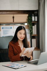Business woman using tablet and laptop for doing math finance on an office desk, tax, report, accounting, statistics, and analytical research concept