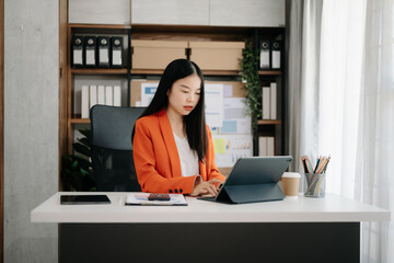 Business woman using tablet and laptop for doing math finance on an office desk, tax, report, accounting, statistics, and analytical research concept