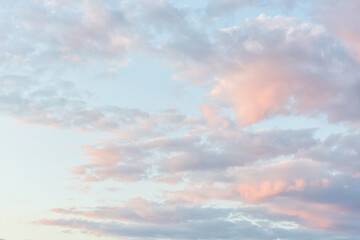 Beautiful fluffy clouds painted in pastel colors at sunrise. Multicolor background or wallpaper