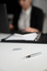 Female secretary working in the office. Notepad on the white table.