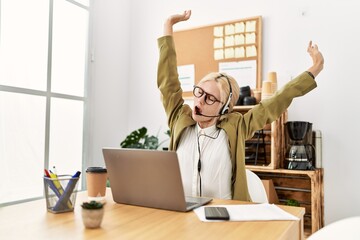 Young blonde woman business worker agent tired stretching back at office