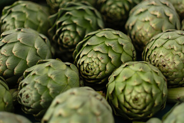 Obraz premium Artichokes are laid out on a table, for sale at a farmers market.