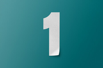 White paper type paper alphabet number 1 isolated on green background.
