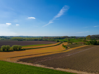 Obraz premium Behold the mesmerizing aerial view of the Belgian Pajottenland area, where patches of vibrant farm fields form a breathtaking patchwork of beauty. This captivating footage showcases the picturesque
