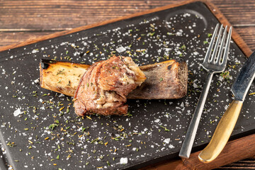 Beef rib asado on stone cutting board at steakhouse