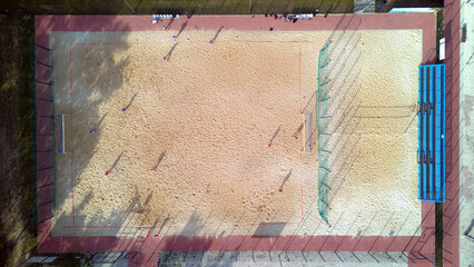 Aerial top down view of a football and valley court on the beach sand in the resort.
