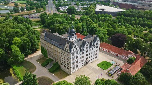 Drone shot of Wolfsburg Castle ( Schloss Wolfsburg ) . The Wolfsburg is a medieval lowland and water castle in North Germany .