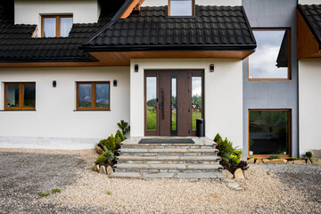 Facade of the villa. Entrance steps to the house. New facade of the villa, windows and doors with a...