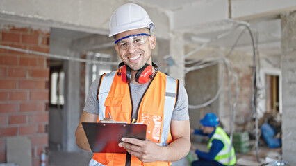 Two men builders writing document working at construction site