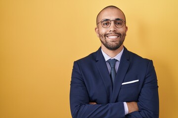 Hispanic man with beard wearing suit and tie happy face smiling with crossed arms looking at the camera. positive person.