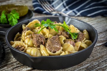 Italian pasta shells with beef sauce in cast iron pan.