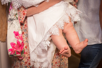 Feet of a child at the sacrament of baptism. A little girl's foot and a white canvas.