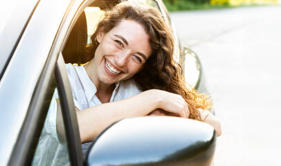 Photo of positive delightful woman driver enjoying car ride - Happy young female buying new auto -...
