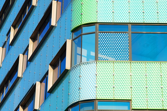 Closeup of a facade of a green and blue modern office building in Arnhem in the Netherlands