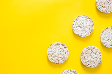 Creative layout made of rice cakes on the yellow background, flat lay.