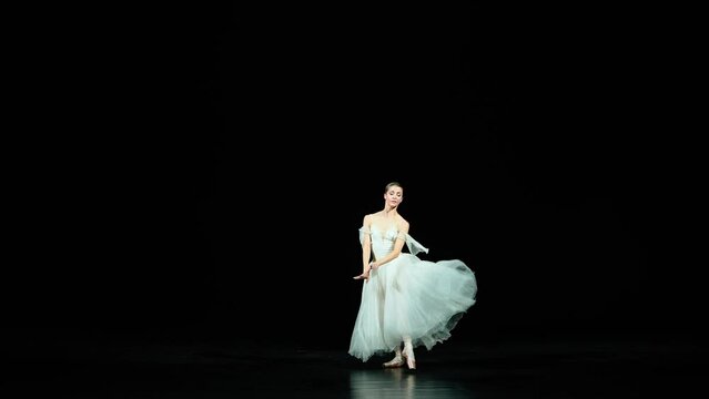 Ballet, graceful ballerina in a white tutu dance and perform choreographic elements on a black background, beautiful dramatic dance.