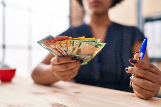 African american woman ecommerce business worker holding australian dollars at office