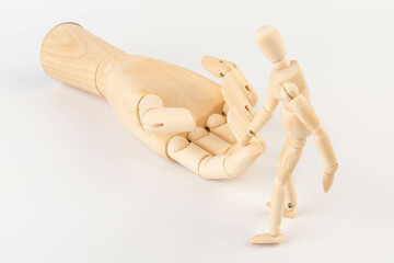 Wooden mannequin and hand on white background