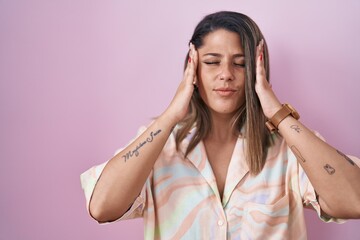 Blonde woman standing over pink background with hand on head for pain in head because stress. suffering migraine.