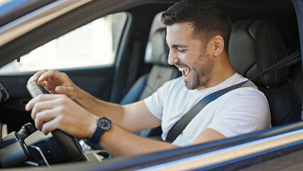 Fototapeta na wymiar Young hispanic man smiling confident driving car at street