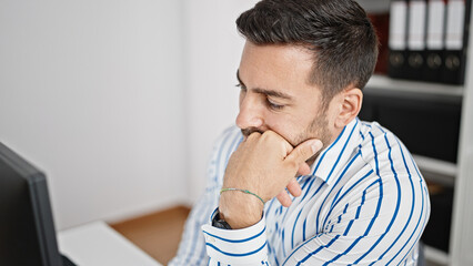 Fototapeta premium Young hispanic man business worker tired working at office