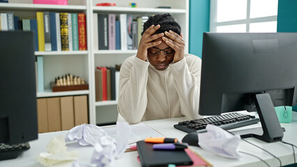 African american woman student using computer stressed at library university