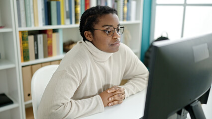 African american woman student using computer studying at library university