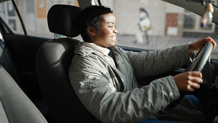 African american woman smiling confident driving car at street