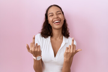 Young hispanic woman wearing casual white t shirt showing middle finger doing fuck you bad...