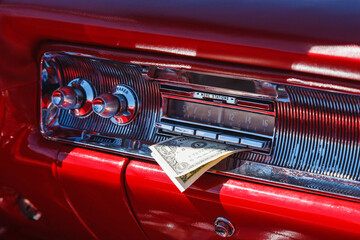 Car radio in an old classic car with a one dollar
