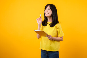 young Asian woman wearing yellow t-shirt and jeans showing happy smile while using digital tablet, displaying thoughtful expression and creative idea. education technology innovative thinking concept.