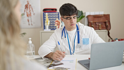 Young hispanic man doctor having medical consultation at clinic