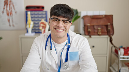 Young hispanic man doctor smiling confident wearing stethoscope at clinic