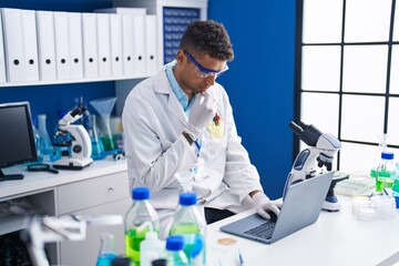 African american man scientist using laptop working at laboratory