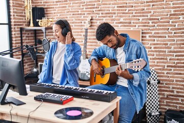 Man and woman musicians playing classical guitar singing song at music studio