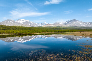 Mountain landscape with a reflection on a calm lake in Rondane National Park, Norway