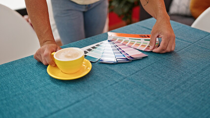 Fototapeta na wymiar Young man choosing paint color drinking coffee at dinning room